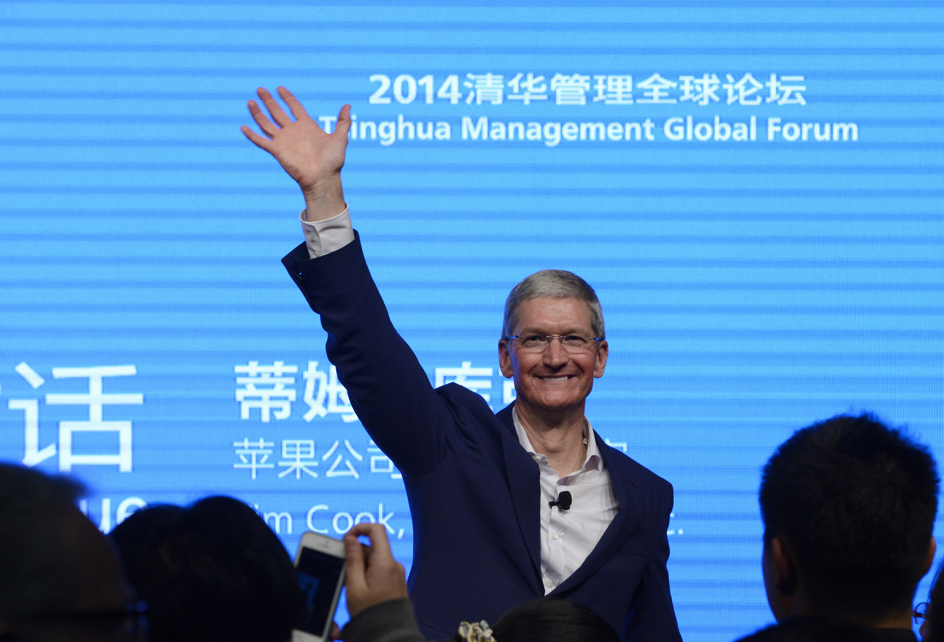 Apple CEO Tim Cook waves as he attends a talk at Tsinghua University in Beijing