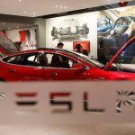 下載自路透 A man looks around Tesla Motors' Model S P85 at its showroom in Beijing January 29, 2014. REUTERS/Kim Kyung-Hoon/File Photo - RTSMACQ