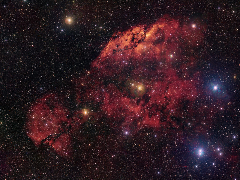 紅光與暗塵交織的「視錯覺」，ESO 公布最新船尾座星雲壯麗影像